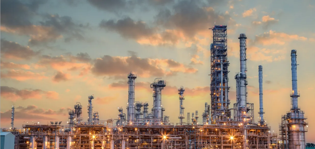 Refinery process columns and stacks illuminated at sunset